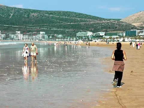 Plażowicze na szerokiej, piaszczystej plaży w Agadirze w słoneczny dzień